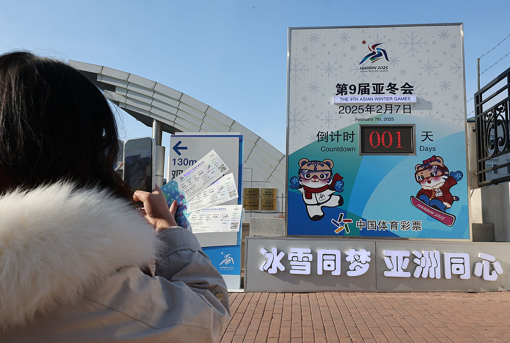 △2025年2月6日，哈尔滨亚冬会倒计时一天，市民前往倒计时牌前打卡纪念。（图自视觉中国）