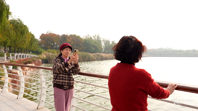 市民在静湖湖畔拍照打卡（央广网发 蔺子贤 摄）