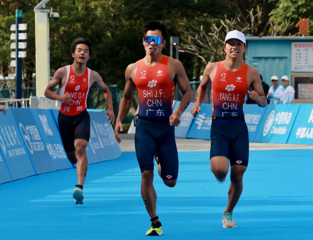 ↑11月27日，广东一团选手石金飞（中）与引导员杨奥富在跑步比赛中冲刺