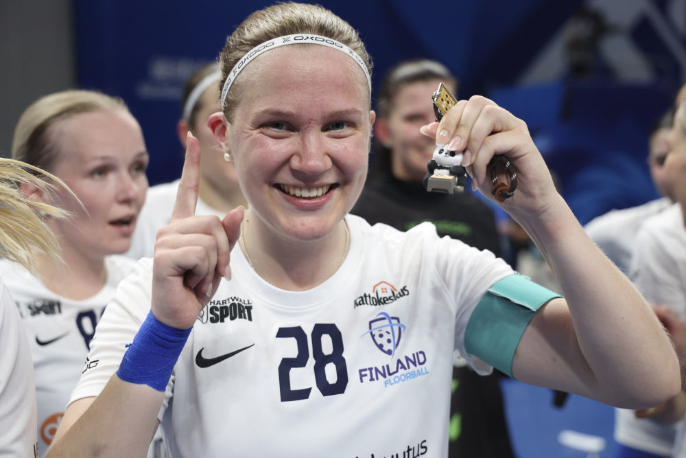 ↑8月13日,芬兰队队长薇拉·考皮(前)在成都世运会软式曲棍球女子金牌赛后展示她的“幸运熊猫”挂件。