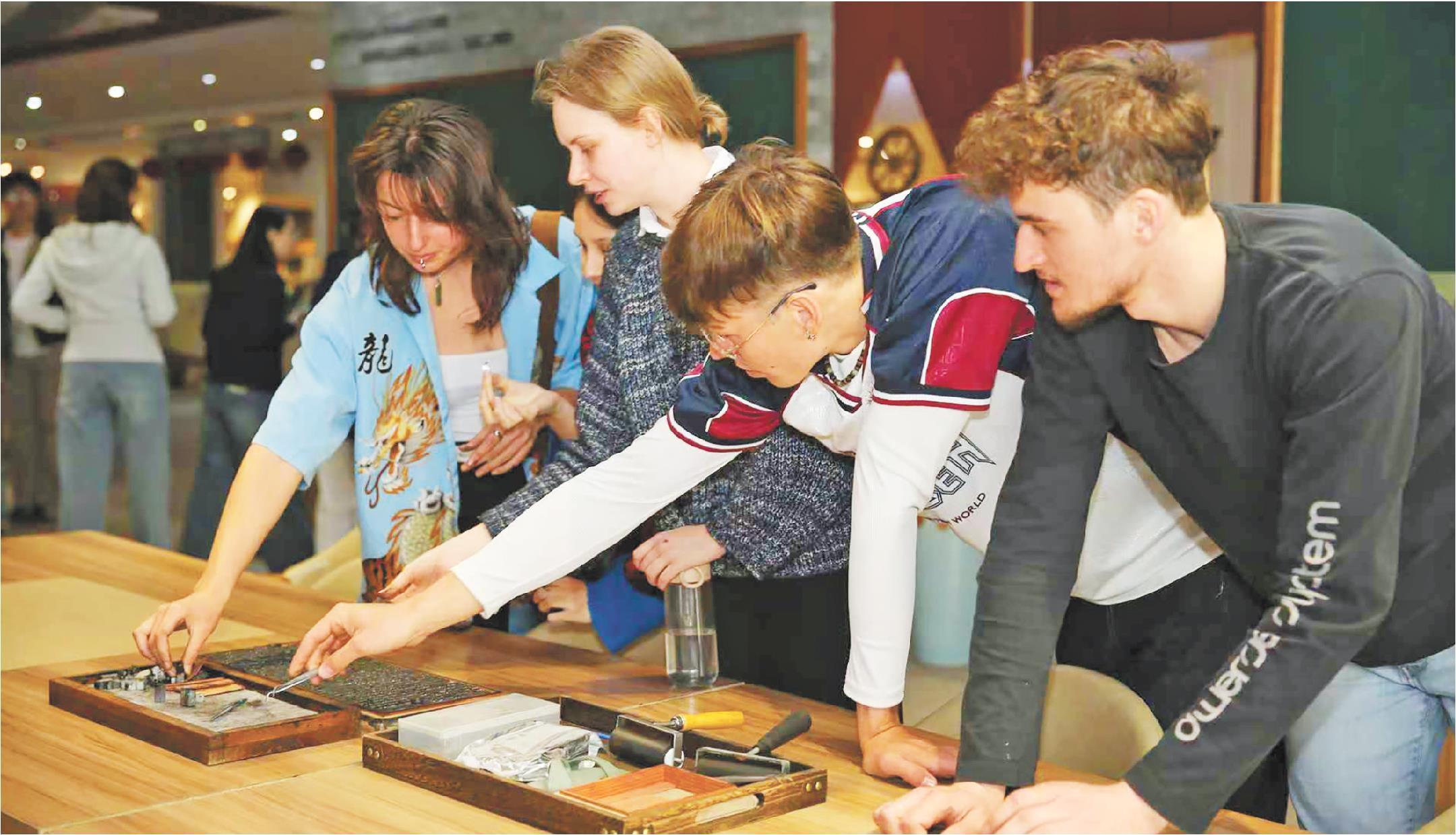 2025“国际中文日”活动上，留学生在体验活字印刷。（□通讯员孔勇报道）