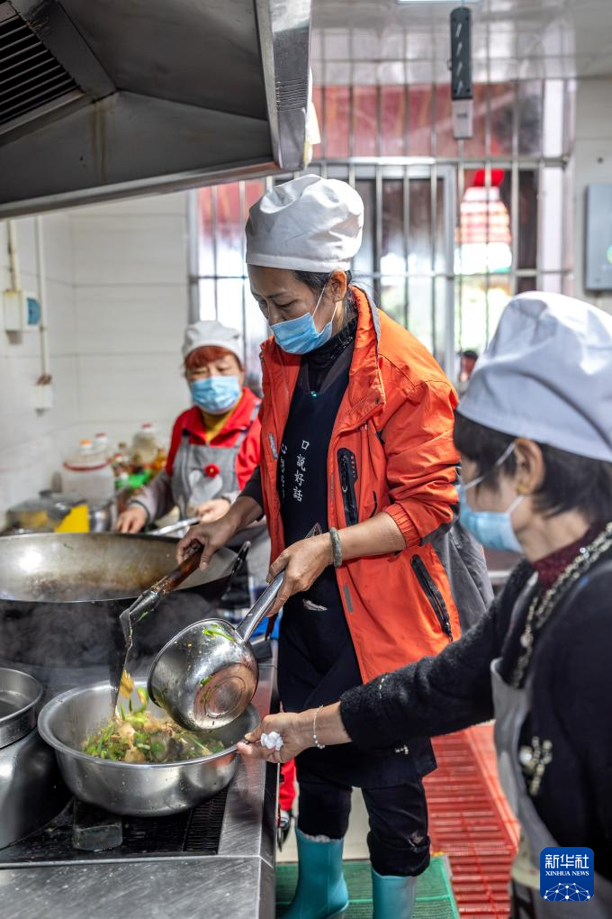 王兰兰(中)在昆明市幸福家园小区爱心食堂做饭(5月28日摄)。