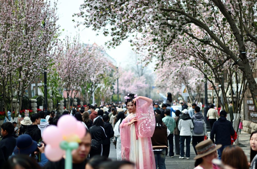 4月4日，一名穿着传统服饰的游客在天津市五大道大理道上拍照。新华社记者赵子硕 摄