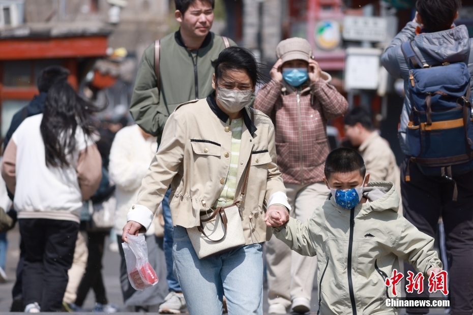 4月12日，市民顶风出行。当日白天，北京大风进入本次过程最强时段。中新社记者 贾天勇 摄