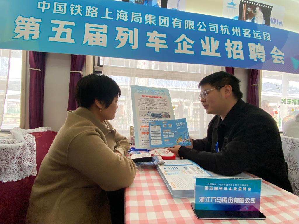 2月13日，在K210次列车上，企业招聘负责人向旅客介绍企业情况。新华社记者魏一骏 摄