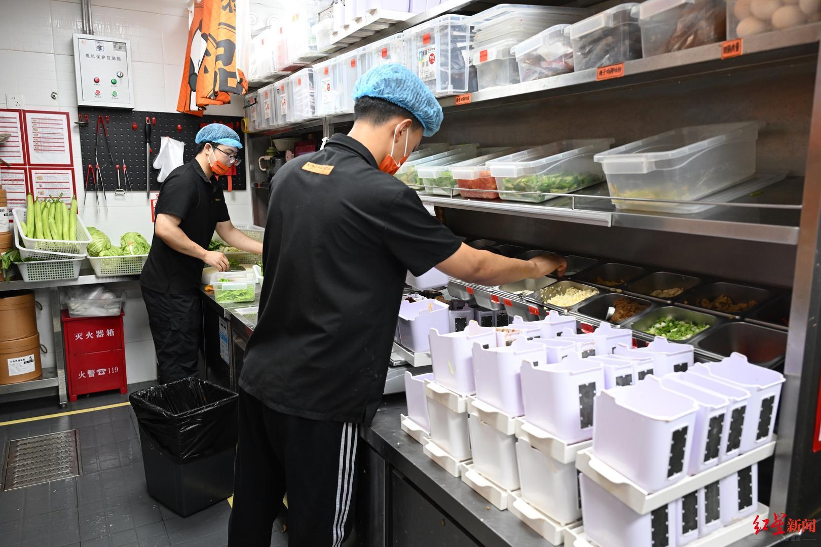 工作人员正在为炒菜机备料.JPG