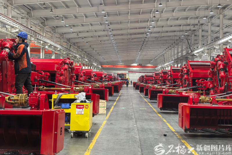 在新疆钵施然智能农机股份有限公司乌苏厂生产车间里，工人正加紧组装最新款棉花秸秆打包一体机。摆瑾焱摄