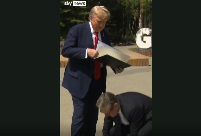 6月的G7峰会上,斯塔默为特朗普弯腰捡掉下的文件 视频截图