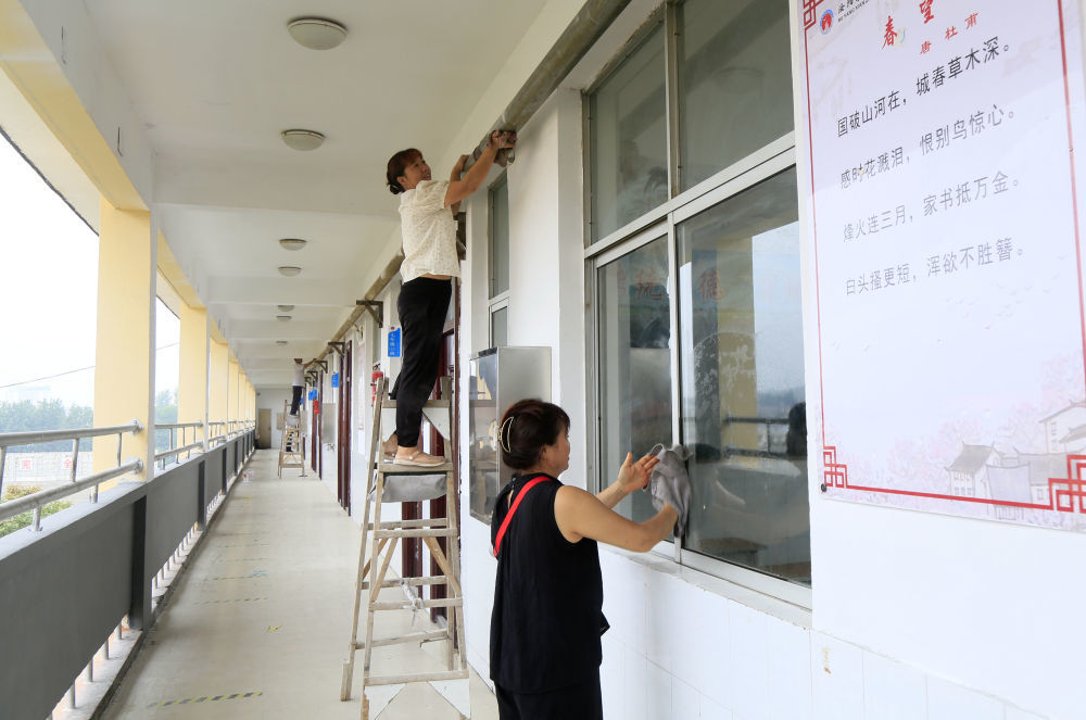 8月25日,工作人员在河南省洛阳市汝阳县直属初级中学进行校园卫生清理。新华社发(康红军摄)