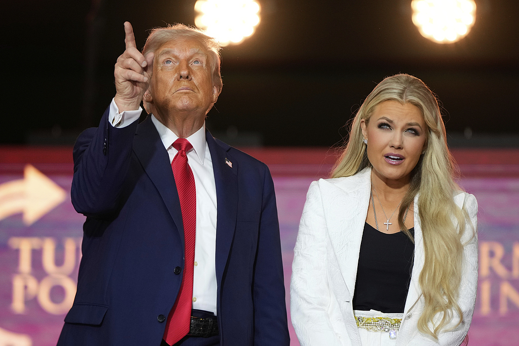 柯克追悼会上，美国总统特朗普同柯克遗孀埃丽卡共同站在台前。（视觉中国）