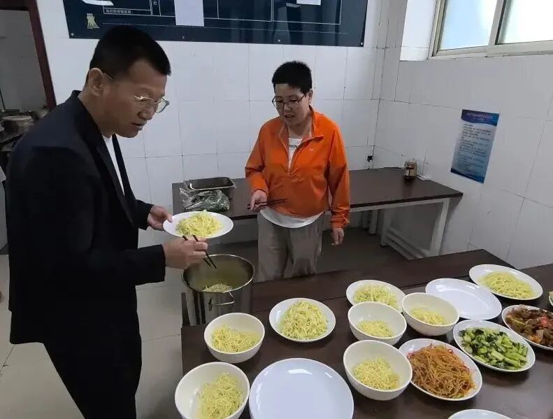 郑培林(左一)和妻子周花为空军某部官兵准备特色美食