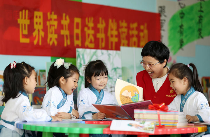 2025年4月23日，山东省临沂市郯城县妇联志愿者为郯城街道中心幼儿园的孩子们讲绘本故事。新华社发（张春雷摄）