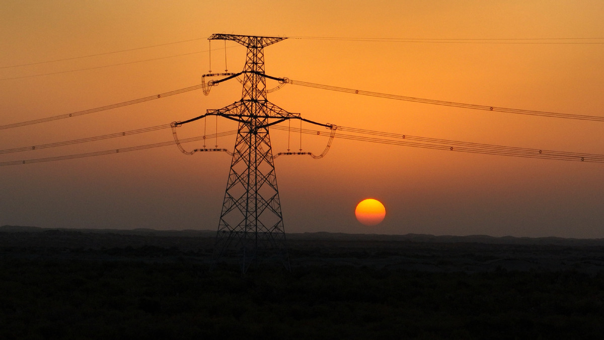 2025年10月18日,落日余晖中的民丰—且末—若羌750千伏输电线路工程。(马元 摄)