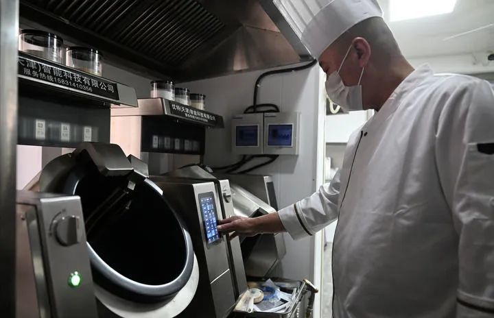厨师在天津市和平区南营门街道的老年人“智慧食堂”后厨操作炒菜机器人。 新华社记者 赵子硕 摄