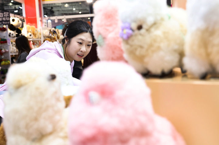 2025年11月8日,在第八届进博会消费品展区,参观者在秘鲁温暖驼品牌的羊驼毛制品前驻足观看。新华社记者 方喆 摄