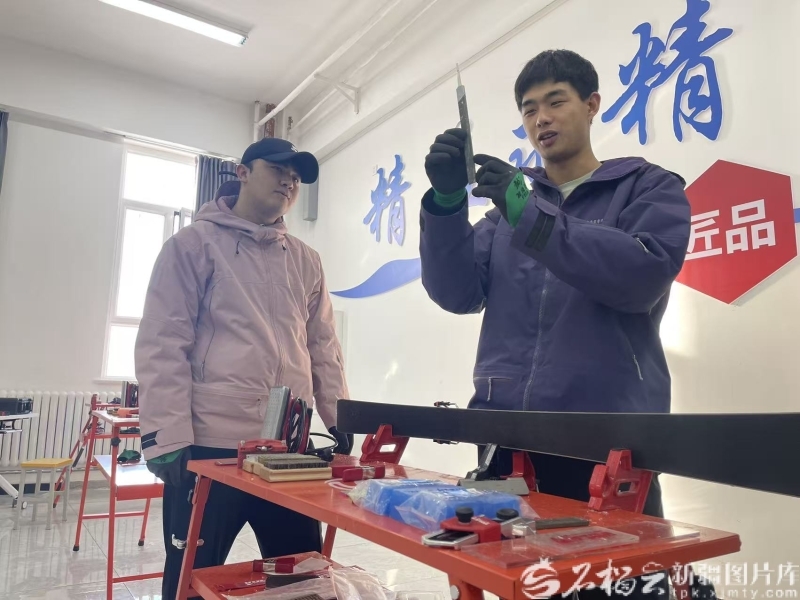 12月3日，朱万鹏（右）教学生进行雪板维护。石榴云/新疆日报记者 赵西娅摄