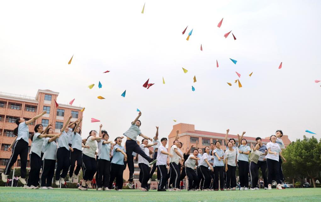 5月22日，在山东省高密市第五中学，高三学生将写有梦想的纸飞机抛向空中。高考临近，各地学校组织高三学生开展不同形式的减压活动，帮助学生放松心情，迎接高考。 新华社发（李海涛摄）