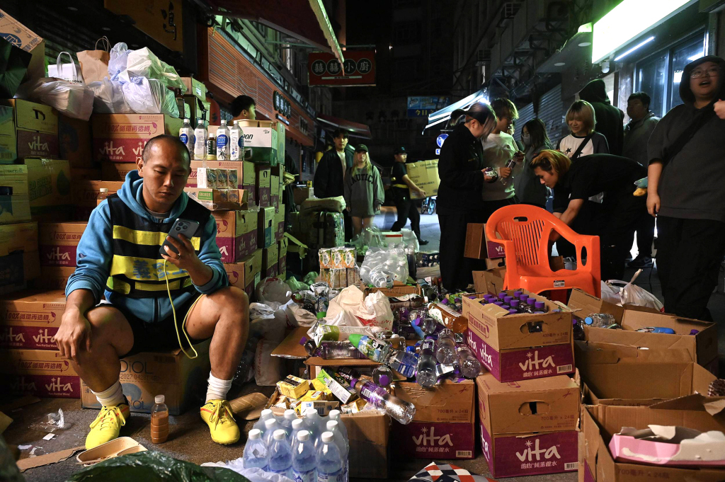 11月27日,香港,消防员在一家充当临时避难所的餐厅外搬运物资。