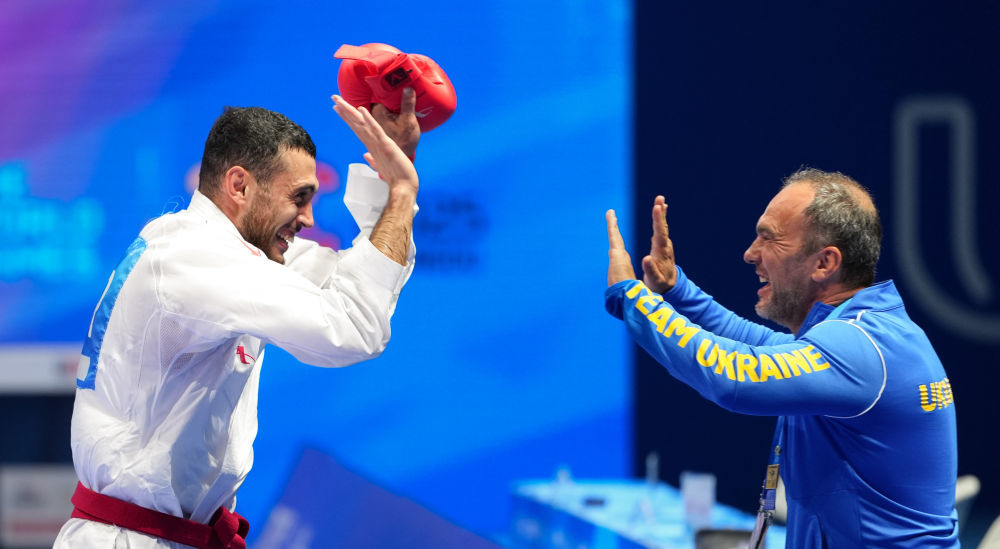 8月9日,乌克兰选手塔利博夫(左)在2025年成都世运会空手道男子组手84公斤以上级比赛夺冠后与教练庆祝。