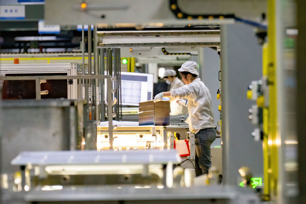 2025年2月13日，在位于安徽省合肥市肥东县的合肥循环经济示范园内一光伏组件企业车间，工人在生产线上忙碌。新华社发（阮雪枫 摄）