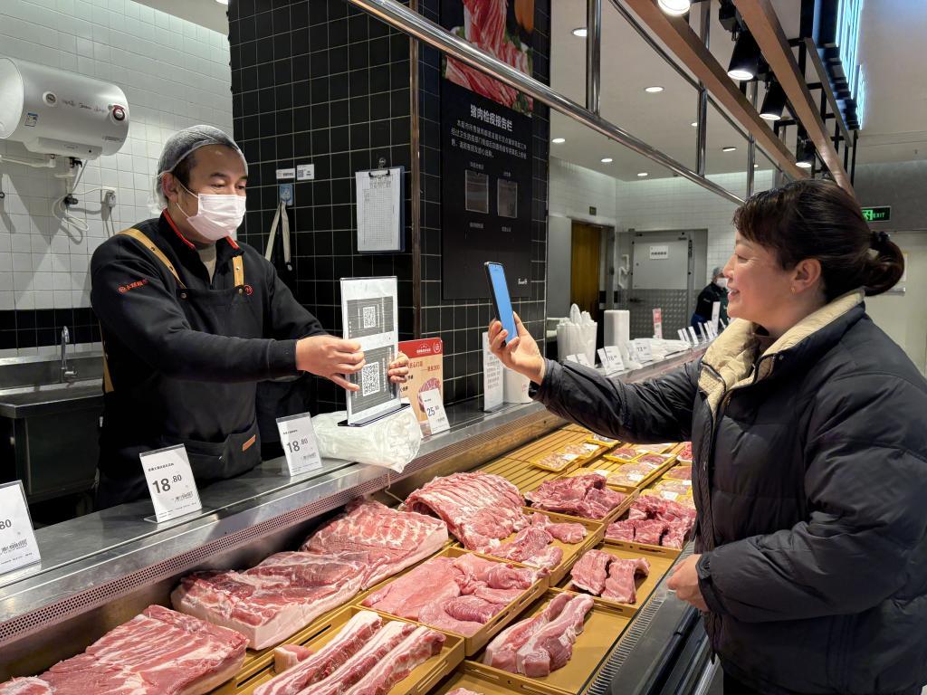 贵阳市一家猪肉生鲜门店内，消费者手机扫码查看相关产品信息。新华社记者 李凡 摄