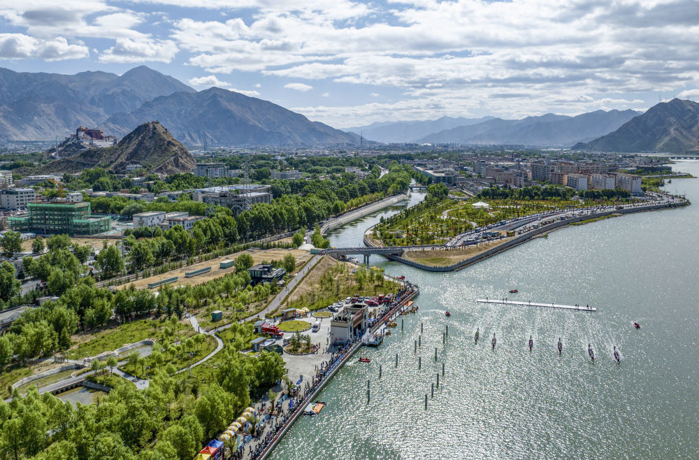 ↑在西藏自治区拉萨市，参赛队伍在“2024年西藏自治区端午节牛皮船（龙舟）赛”中（2024年6月9日摄，无人机照片）。