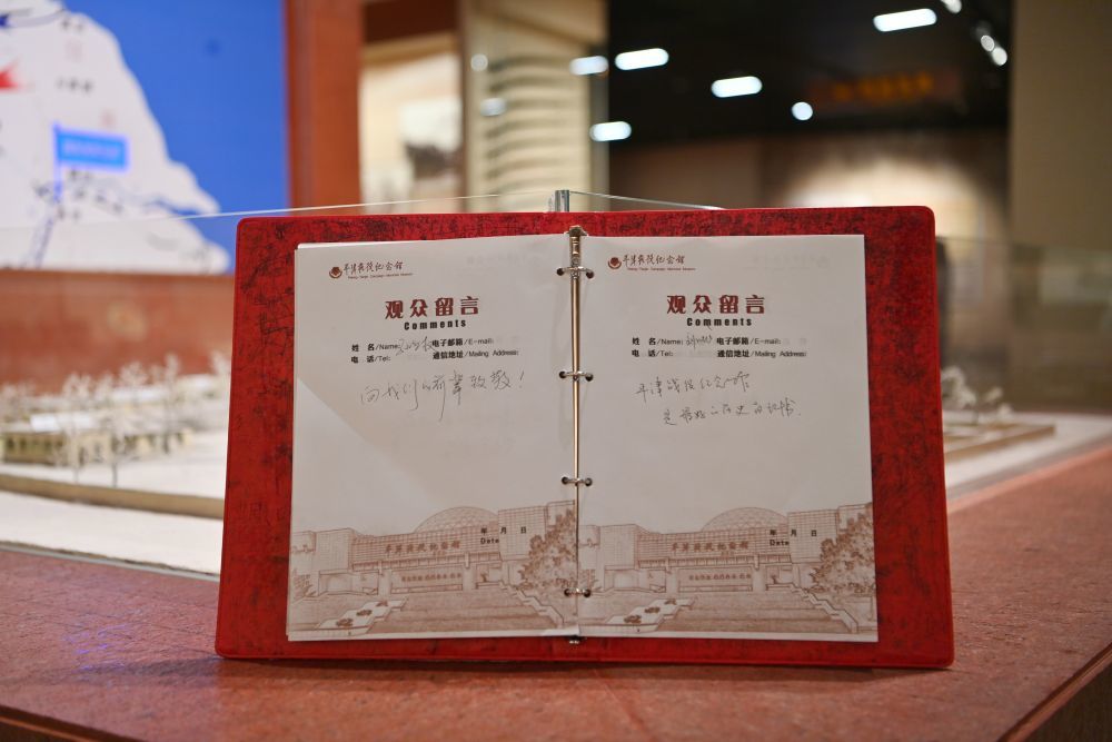 这是2025年3月27日拍摄的平津战役纪念馆观众留言簿。一名观众写下“向我们的前辈致敬！”