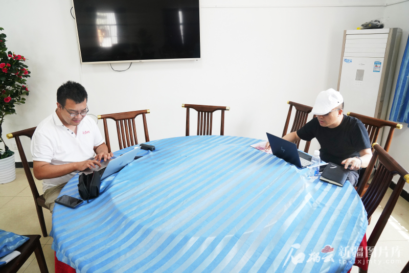 7月1日，在喀什公路事业发展中心疏附养护所盖孜养护站，记者马晋轩（左）和王永飞利用午餐时间准备稿件。