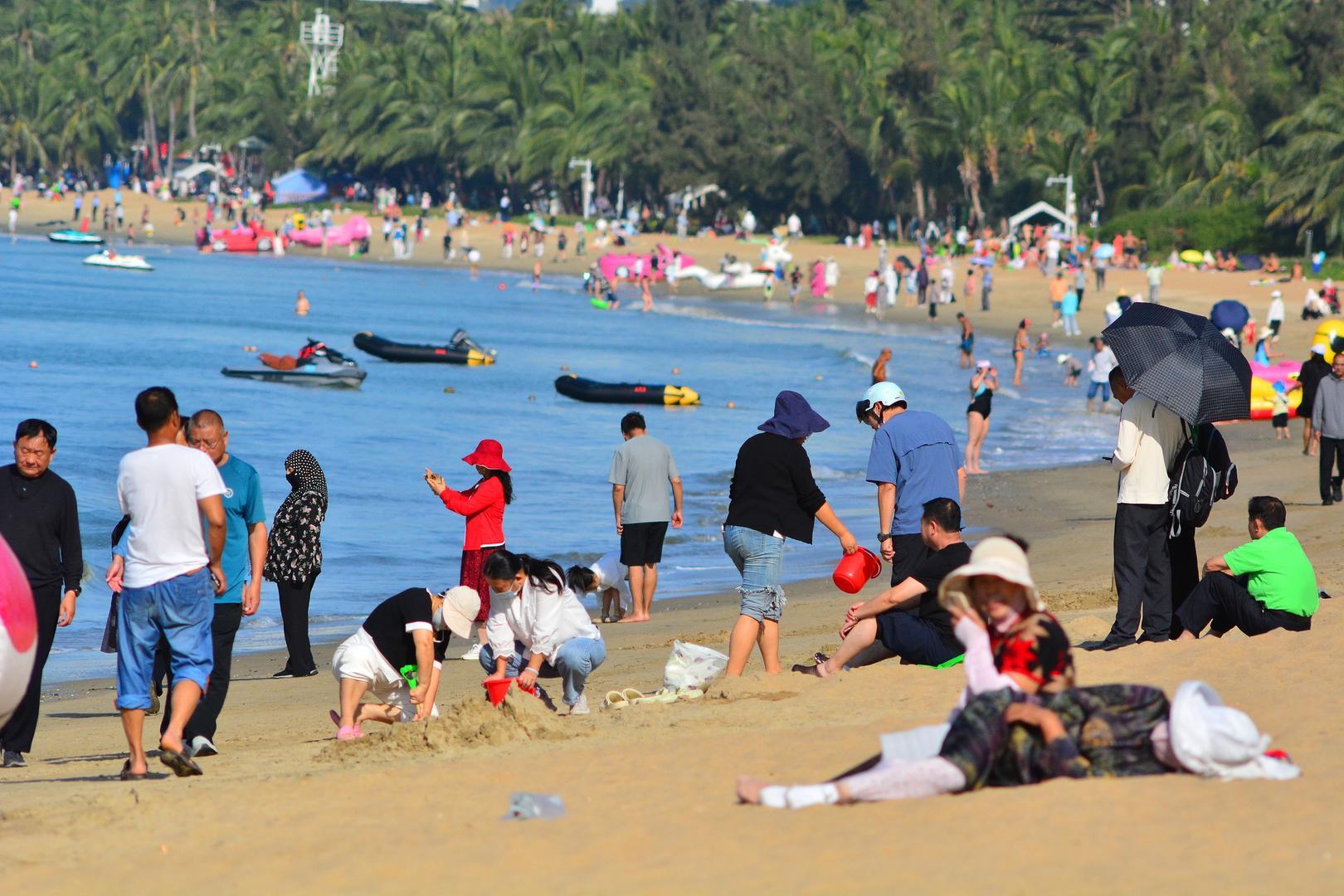 ▲12月18日,海南封关首日,三亚湾人潮涌动,游客前来休闲度假,享受冬日温暖 图据视觉中国
