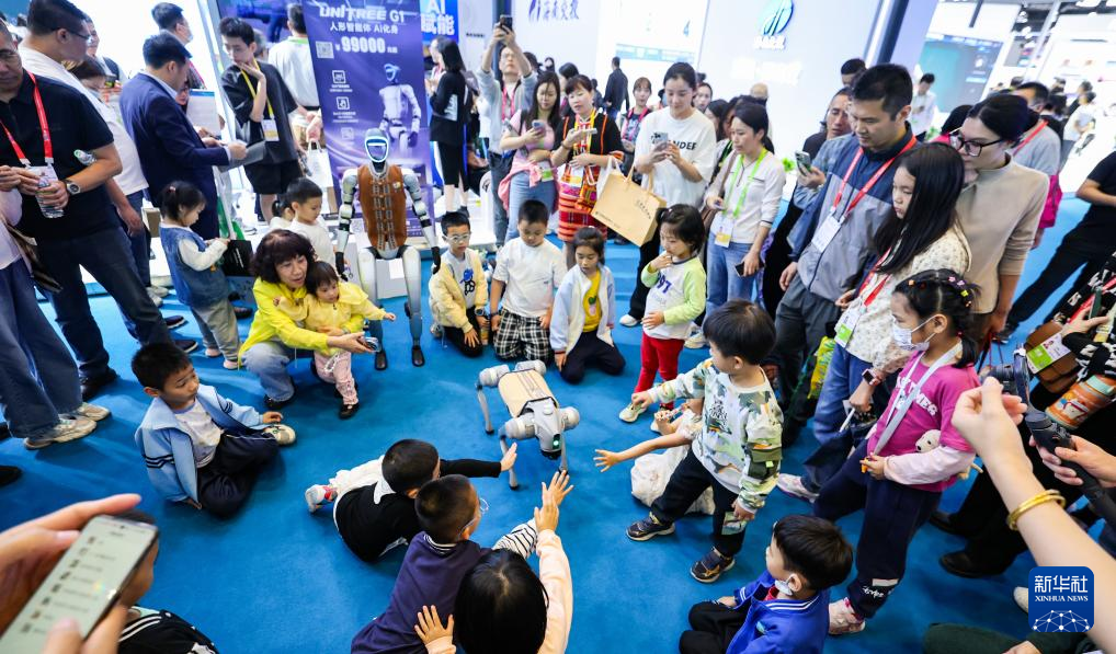 4月13日，在第五届消博会现场，小朋友和宇树科技展示的机器狗互动。新华社记者 杨冠宇 摄