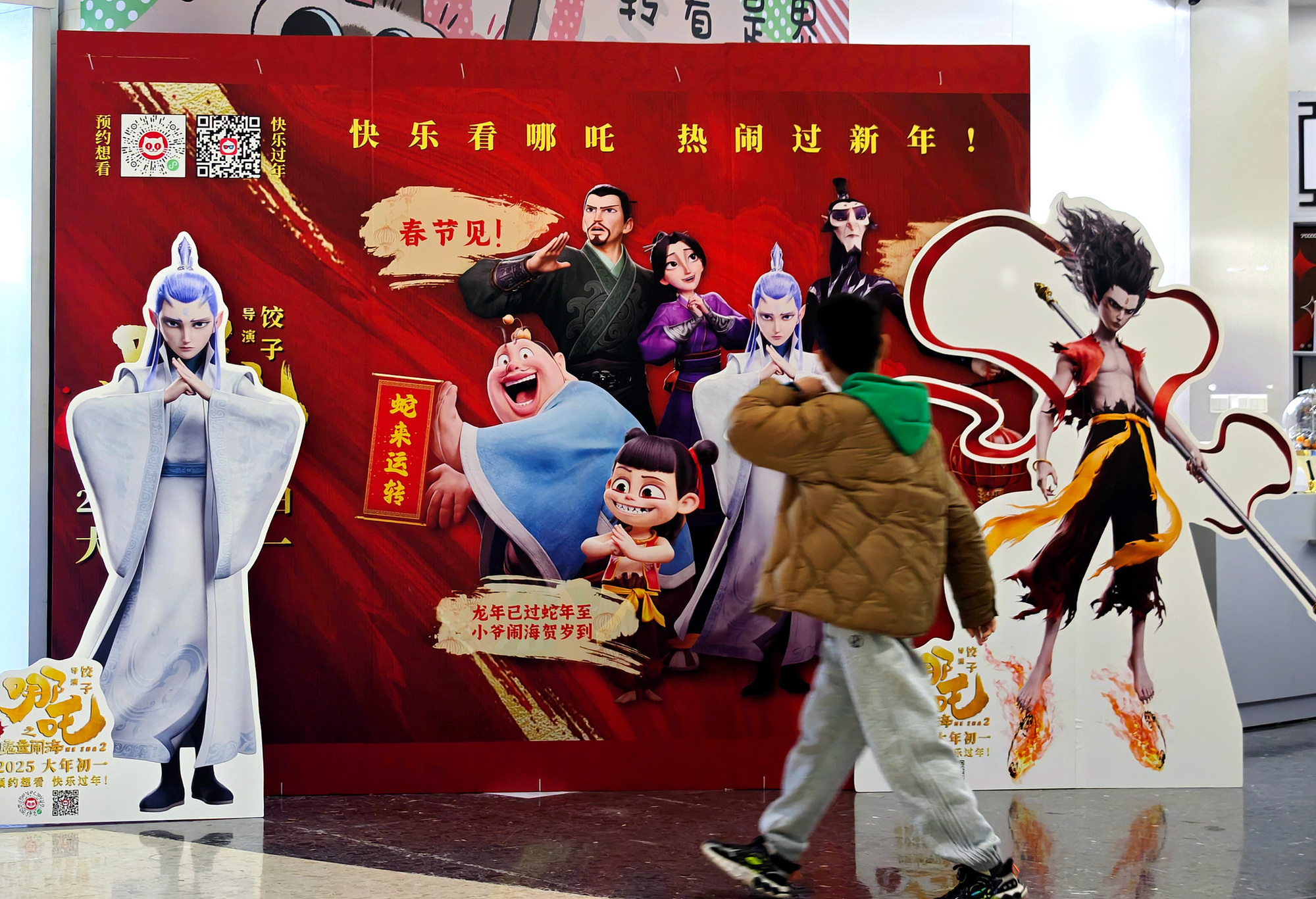 观众从《哪吒2》电影海报前走过