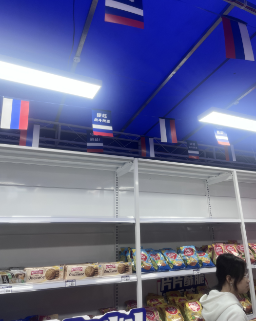 ◆岗顶地铁口“俄罗斯商品馆”内贴有“硬核”“战斗民族”“正品保障”等标语。摄影：一墨