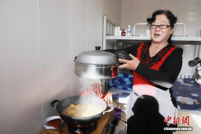 图为李玉霞在独立坝村幸福院做午饭。　中新网记者 张林虎 摄