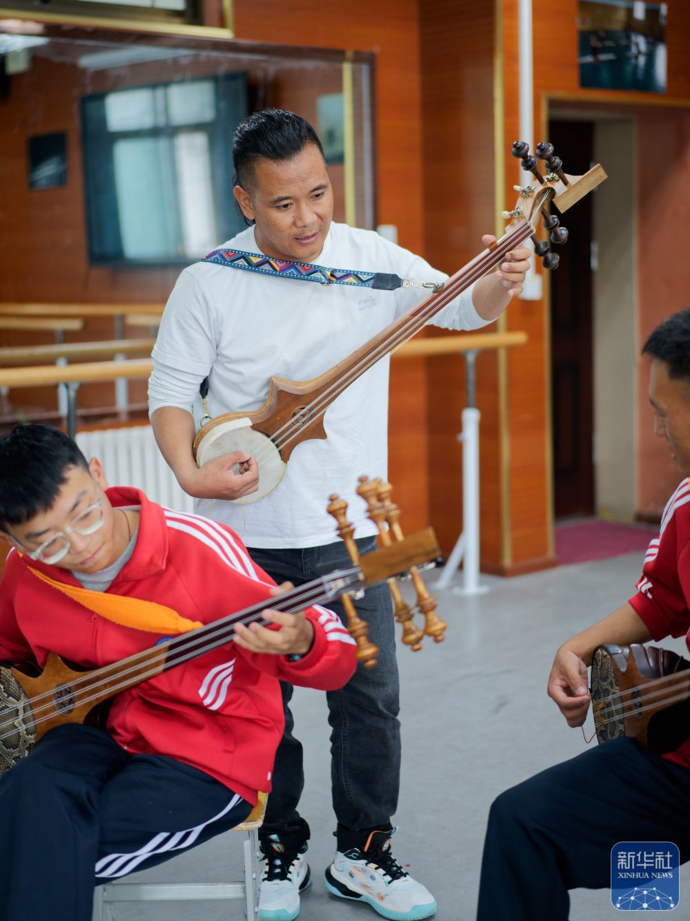 ↑ 9月9日，在拉萨市第二中等职业技术学校，洛桑次仁老师在纠正孩子们弹奏扎念琴的动作。