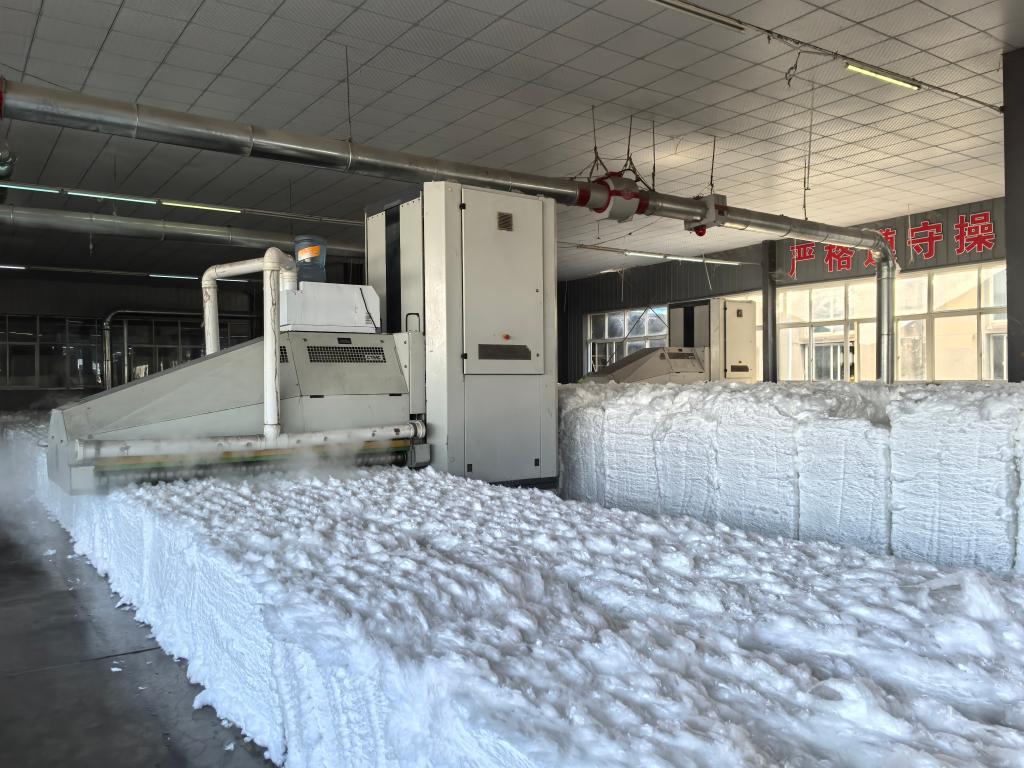 在生产车间，往复式抓棉机正在“吞吐”物料。新华社记者 田中全 摄