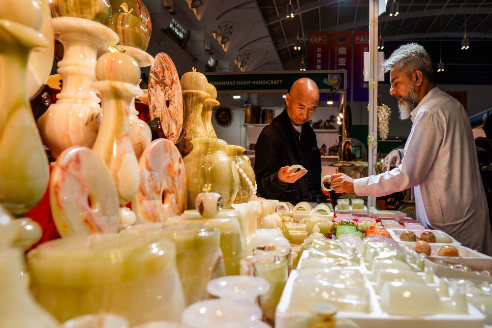 6月20日，顾客在南亚馆巴基斯坦展区选购玉石工艺品。