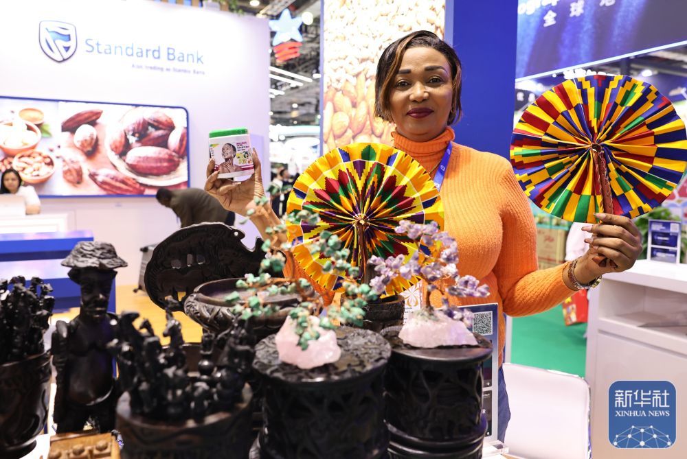 ↑ 11月7日，在第八届进博会农食产品展区，来自加纳的展商展示当地特色折扇和牛油果润肤乳。新华社记者 方喆 摄