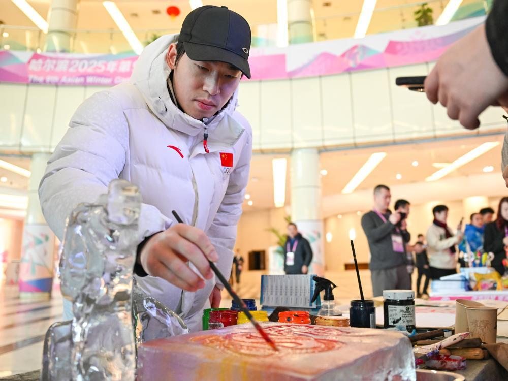 ↑在第九届亚冬会运动员村，中国代表团的冰球运动员张泽森在体验拓彩冰雪画。新华社记者 王曦 摄