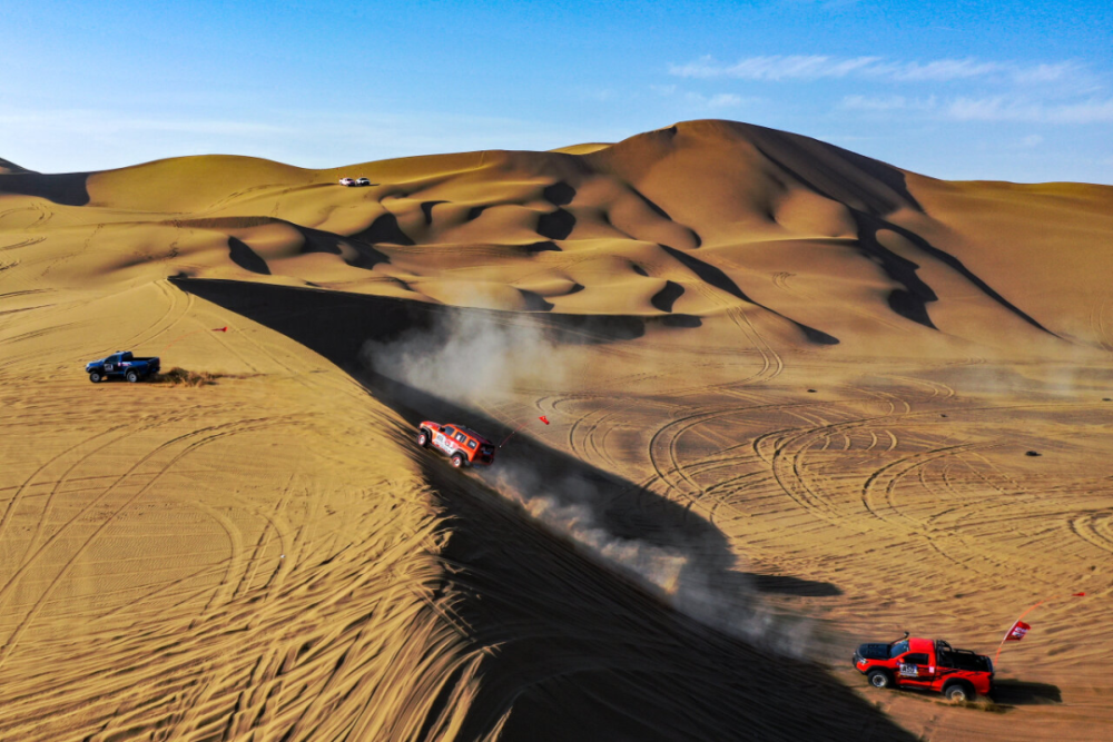 赛车在库木塔格沙漠里驰骋(无人机照片)。周鹏 摄