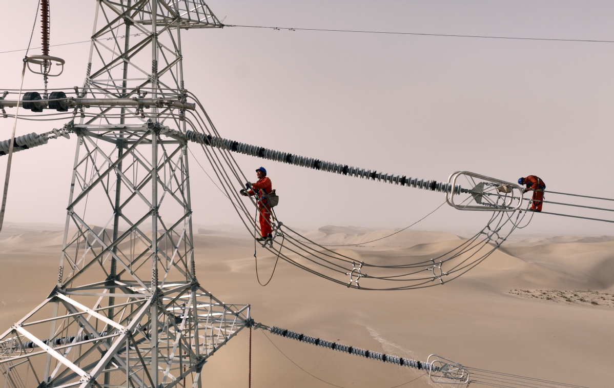 2025年8月8日,民丰—且末—若羌750千伏输电线路工程现场,作业人员开展验收消缺作业。(马元 摄)