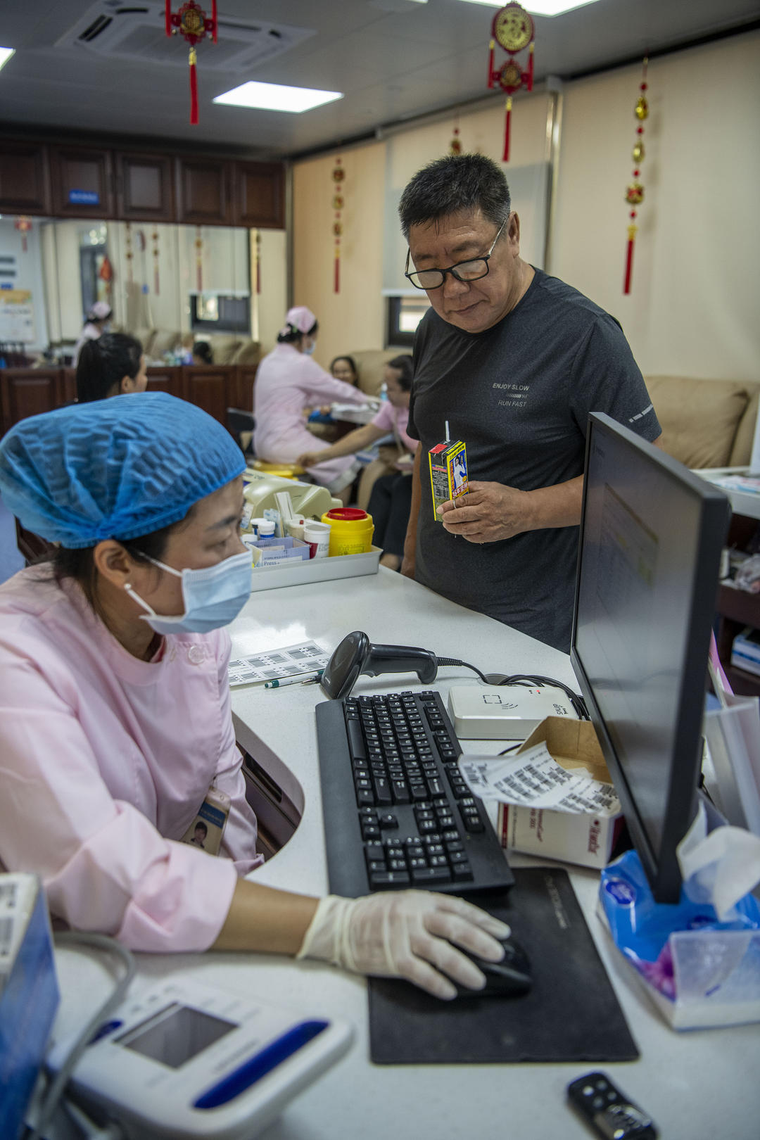 ▲海南琼海东风路献血点,护士为一位老人查阅献血资料 资料图 图据视觉中国