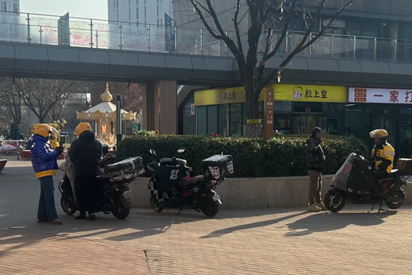 ▲在北京一商业区户外等待订单的骑手