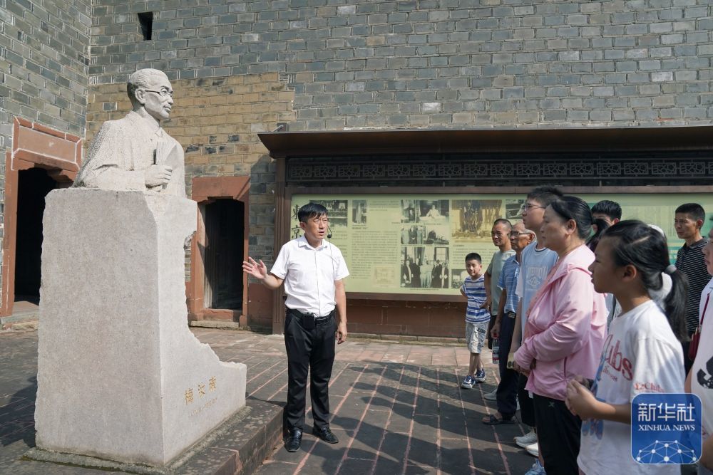 2025年8月1日，梅汝璈故居讲解员梅庭军（左一）向游客介绍梅汝璈。