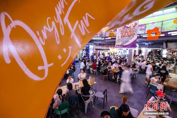 8月7日，游客在贵阳市青云市集选购、品尝当地小吃。 中新社记者 瞿宏伦 摄