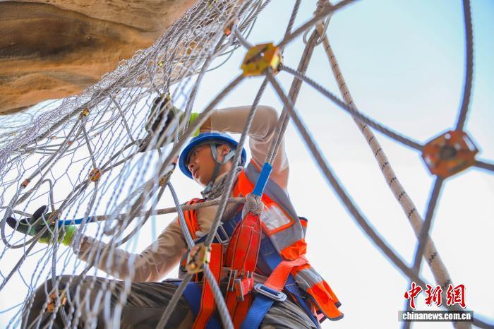 图为兰州铁路局兰州西工务段铁路职工固定柔性主动钢丝网 王光辉 摄