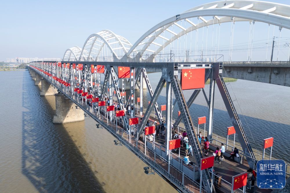 ↑ 10月1日,游客在哈尔滨市滨州铁路桥上游览(无人机照片)。新华社记者 张涛 摄