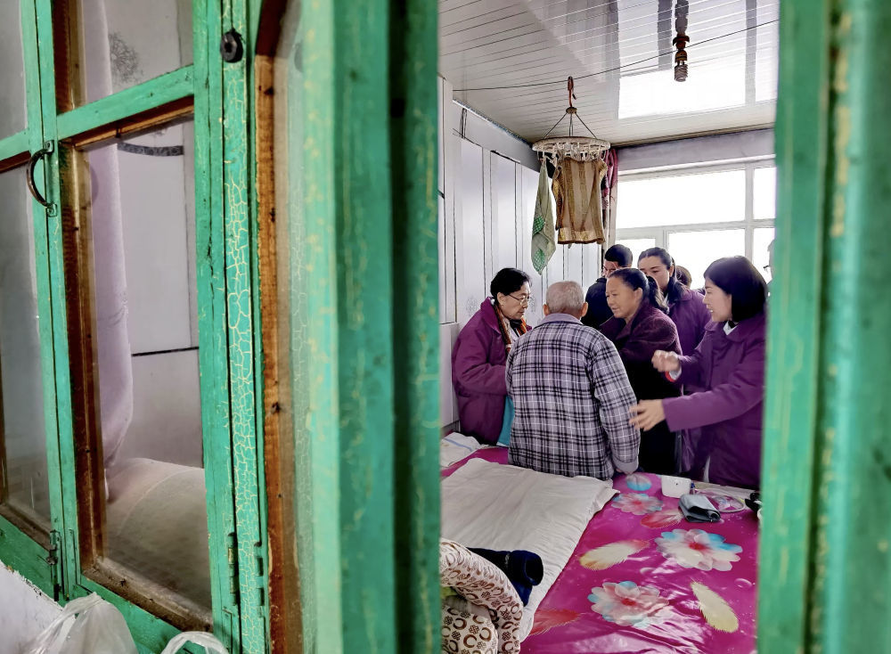 2024年11月26日,87岁的辽宁金秋医院“菊香爱心团队”领队张菊香(左一)冒雪到行动不便的患者家中诊治。多年来,数百名热心公益事业的“菊香爱心团队”医务工作者在辽宁的乡村、街道社区为群众提供优质医疗服务,先后开展大型义诊活动近百次,诊治群众超过6万人次;举办健康科普讲座超过60场,受益群众超过4万人;培训乡村基层医务人员上千人。