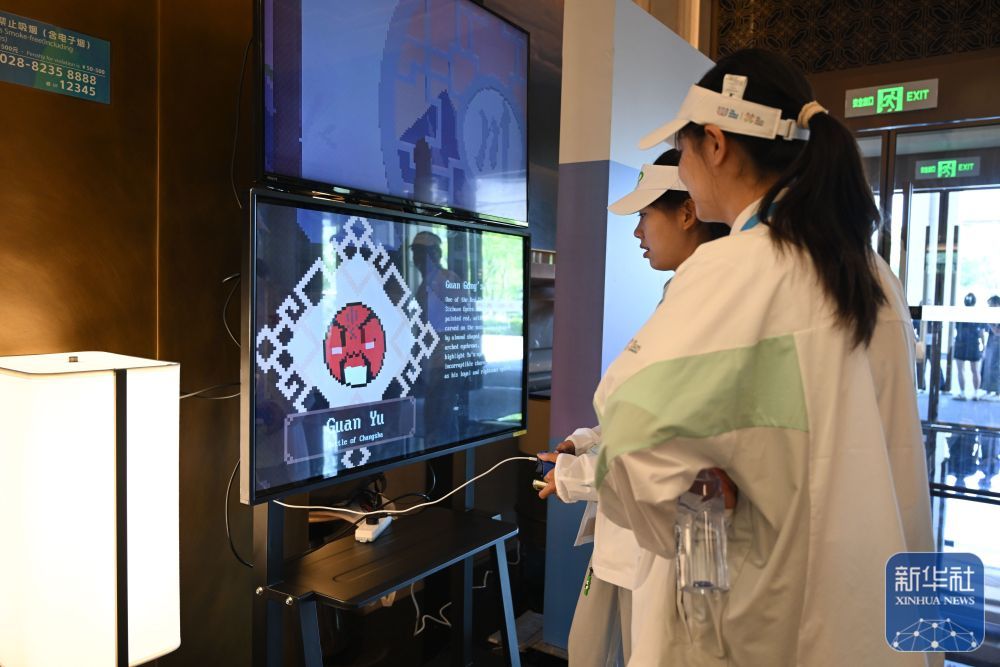 ↑ 在成都世运会运动员村内的互动体验活动区，志愿者体验互动游戏装置。新华社记者 胥冰洁 摄