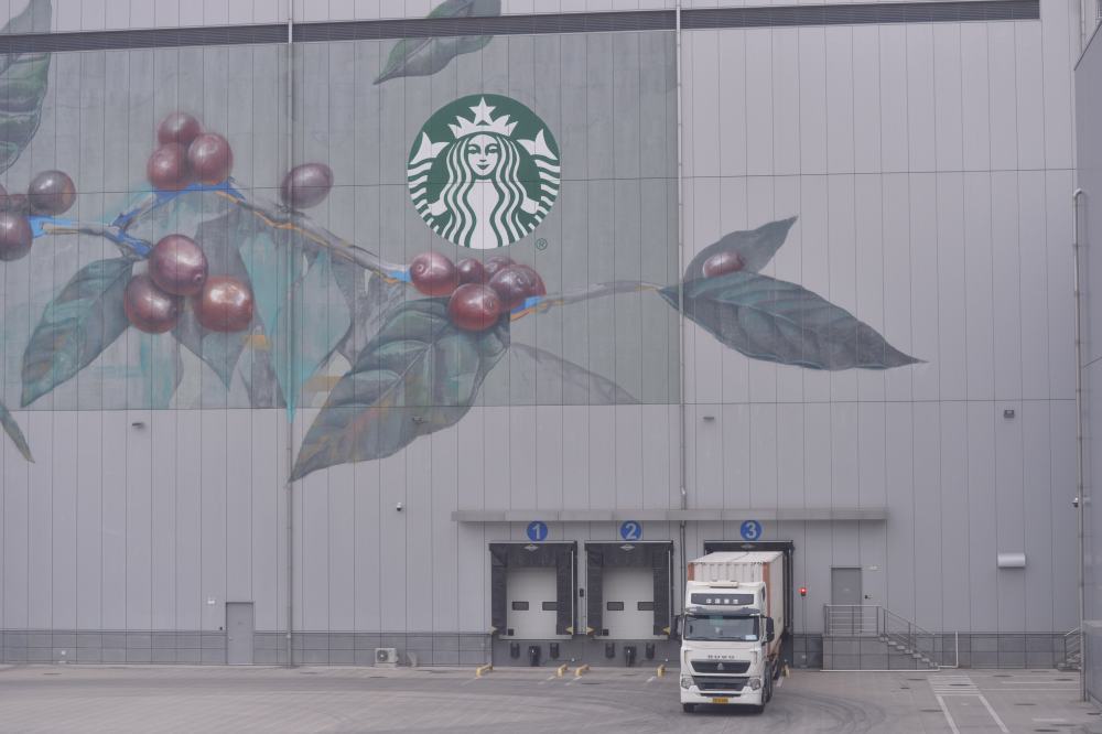 在星巴克中国咖啡创新产业园,咖啡生豆正被卸下车。新华社记者刘力航 摄