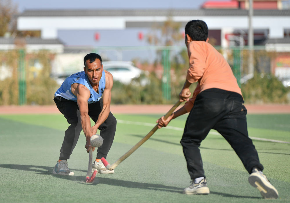 2024年11月8日，在新疆于田县体育场，阿卜杜拉艾孜则&middot;阿卜杜海娃尔（左）和队友在训练中拼抢。新华社记者 胡虎虎 摄